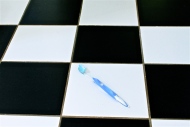 Toothbrush on black and white tiled floor.